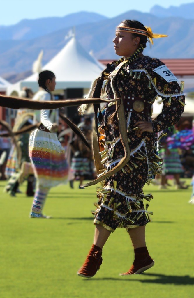 Snow Mountain Paiute Pow Wow Grand Entry - a young woman in a jingle dress dances across the grass.