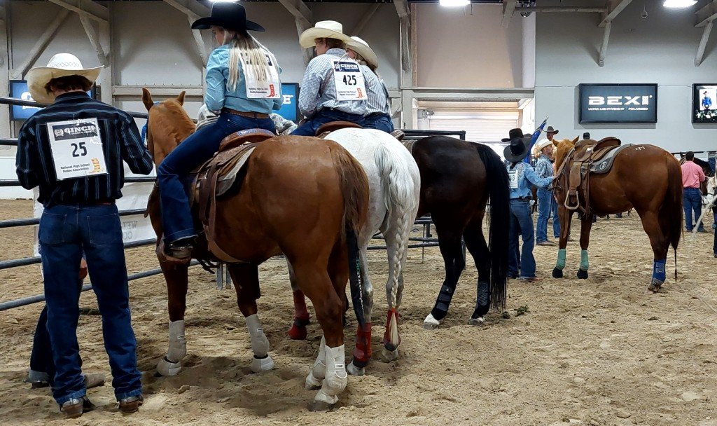 Pre-rodeo, contestants and their horses wait for the National Anthem at Priefert Pavilion as seen at: rodeo Washoe HS; rodeo Wells HS; rodeo White Pine HS; and rodeo NSHSRA.