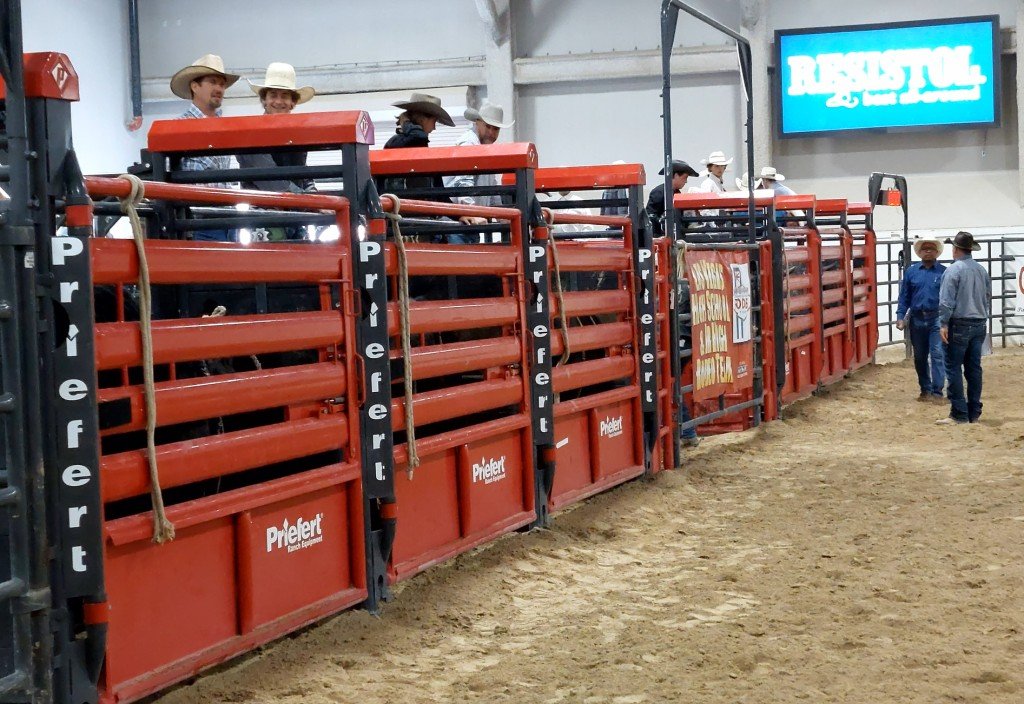 In the bull-riding event, a shot of the enormous, red, rough-stock stockade as rodeo officials await the next bull at Rodeo Priefert Pavilion; Rodeo South Point Arena; Rodeo South Point; & Rodeo NSHSRA.