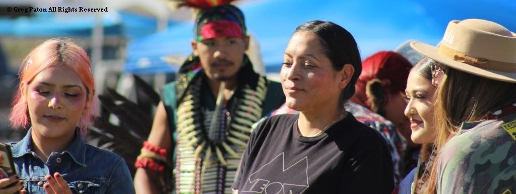 Snow Mountain Paiute Pow Wow at end of Grand Entry as friends share a picture as seen in powwows: Las Vegas Snow Mountain Paiute; Moapa; Moapa Valley; Muckleshoot; Nevada Day; Numaga; Pahrump; Pahrump Valley; Pahrump Valley Social; and Pahrump Social.