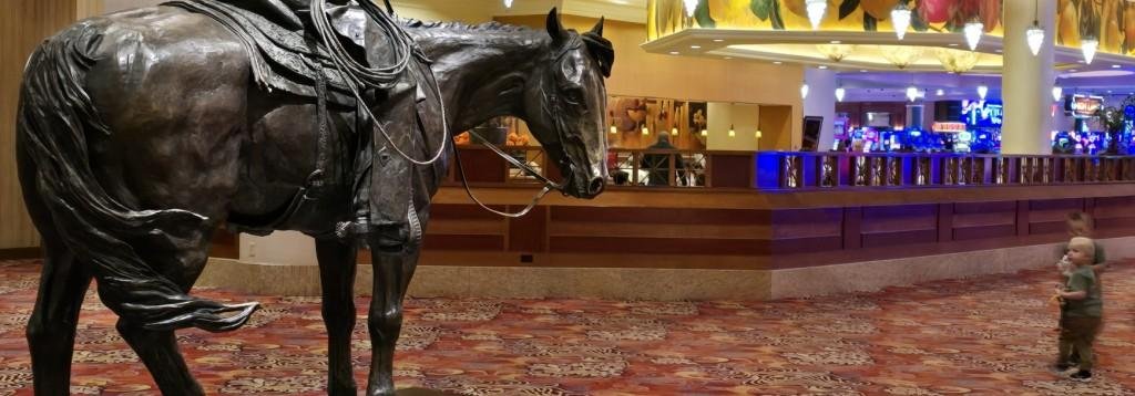 Two children gaze at the iconic cowboy statute in the Lobby of the South Point Arena, Priefert Pavilion and  Equestrian Center.