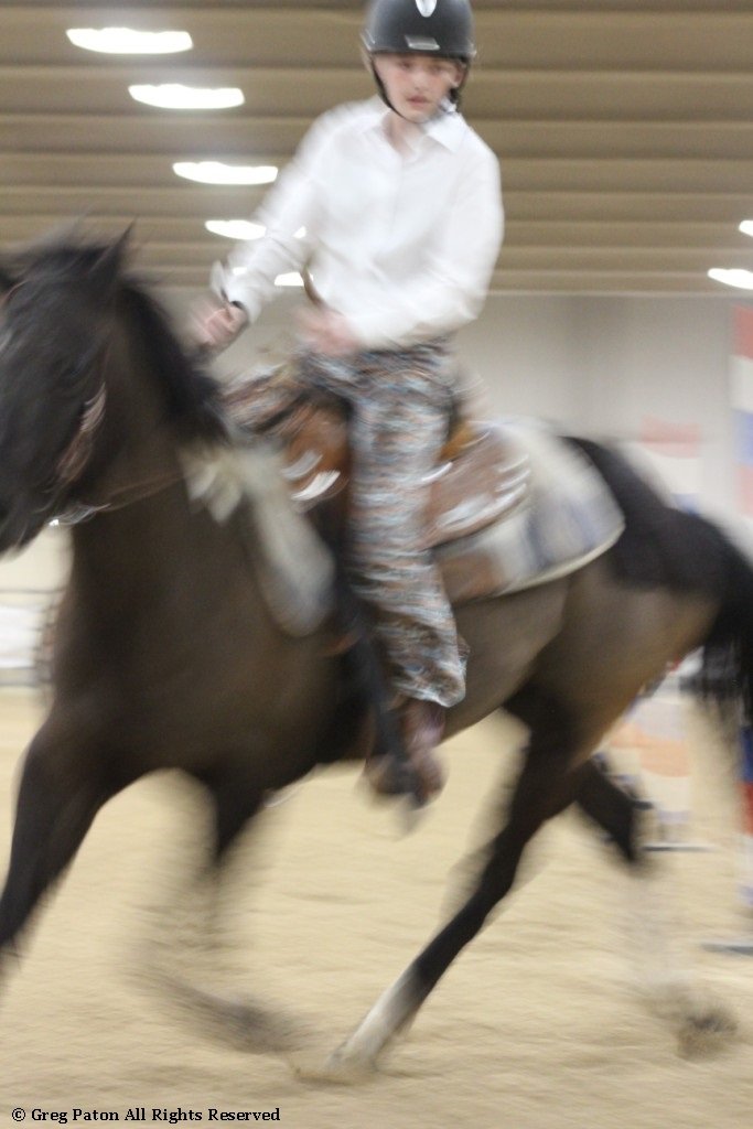 In pole-bending event, closeup of as horse and rider maneuver between poles in the time trials at Priefert Pavilion as seen in high school rodeos: Alamo; Battle Mountain; Boulder City; Pahrump; Pahrump Valley; Elko; Eureka; Fallon; Fernley; Humboldt; Moapa Valley; Spanish Springs; Washoe; Wells; White Pine; NSHSRA; Priefert Pavilion; & South Point.